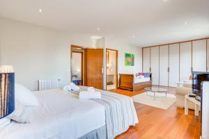 a bedroom with a white bed and a living room at Villa Cala Estancia Mercedes by PriorityVillas in Palma de Mallorca +24 photos