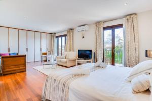 a bedroom with a large bed and a living room at Villa Cala Estancia Mercedes by PriorityVillas in Palma de Mallorca