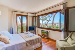a bedroom with a bed and a fireplace and a window at Villa Cala Estancia Mercedes by PriorityVillas in Palma de Mallorca