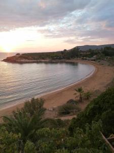 a view of a beach with the sun setting at Dionisis Apartments in Kounopetra