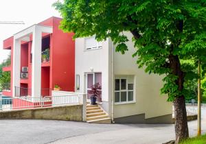 a red and white building with a tree at Studio apartment Stazion with free parking in Pazin