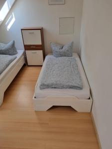 - une petite chambre avec 2 lits et une commode dans l'établissement Ferienwohnung/Monteurwohnung Alte Scheune bei Kassel, à Weimar