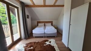 1 dormitorio con 1 cama en una habitación con ventanas en Forestside House Gacka, en Sinac
