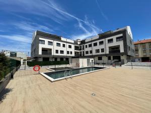 a large building with a swimming pool in front of it at Mar de Llanes in Llanes