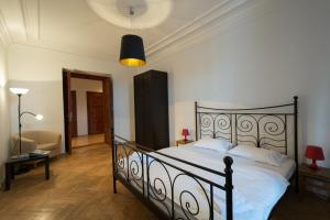 a bedroom with a bed with white sheets and a lamp at Royal Road Residence in Prague