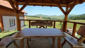 a wooden bench on the porch of a cabin with a view at Apartment Studenac in Zlatibor +35 photos