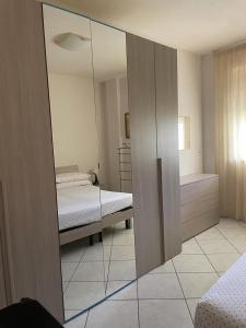 einen Spiegel in einem Zimmer mit einem Bett und einem Schlafzimmer in der Unterkunft Casa Fefe' in Otranto