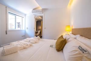 1 dormitorio con 1 cama blanca grande y toallas. en PortugalActive Beach Flat, en Viana do Castelo