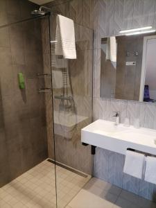 uma casa de banho com um lavatório e um chuveiro em Hôtel Catalpa em Annecy