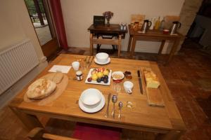 - une table en bois avec de la nourriture dans l'établissement Ancienne Ecole, à Cazaux-Villecomtal