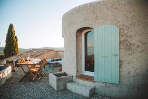 a building with a table and a green door at B&B La Sergerie in Le Lavandou