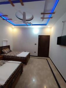 a room with two beds and a ceiling fan at Lavish Inn Islamabad in Islamabad