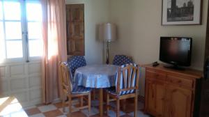 a dining room with a table and chairs and a television at Precioso apartamento costa Murciana in Puerto de Mazarrón