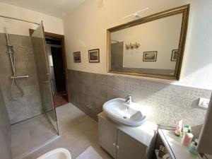 Un baño con lavabo, ducha y espejo. en Casa del lago, en Menaggio 64 fotos más
