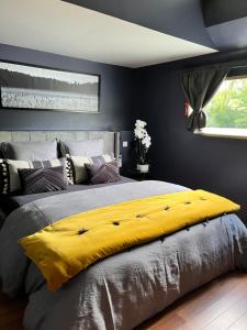 sypialnia z dużym łóżkiem i żółtym kocem w obiekcie Péniche Santa Julia au port de Chantilly Insolys w mieście Saint-Leu-dʼEsserent