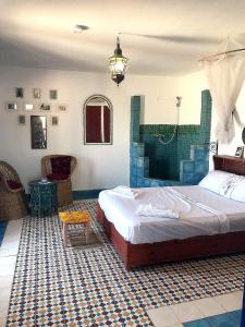 a bedroom with a large bed and a table at Tigmi surf morocco in Tiguemmi nʼAït Bihi
