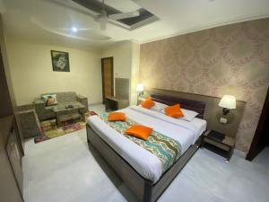 a bedroom with a large bed with orange pillows at Hotel Sagar in Guwahati