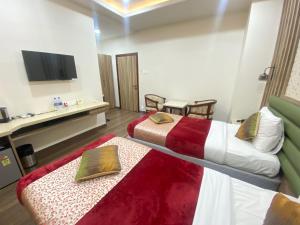 a hotel room with two beds and a flat screen tv at Hotel Sagar in Guwahati