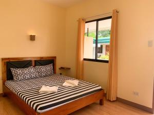 1 dormitorio con cama y ventana en Midnite Inn, en Panglao