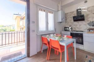 a kitchen with a table and chairs and a balcony at Como Holiday Home Appartamento ideale per famiglie in Como