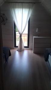 a room with a window with a curtain at Malaga in Gąski +8 photos