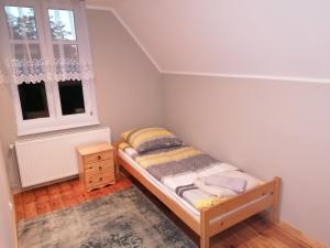 um pequeno quarto com uma cama e uma janela em Apartament nad kanałem em Giżycko