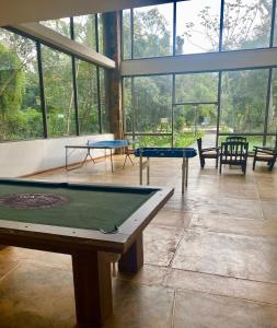 um quarto com duas mesas de pingue-pongue e janelas em Rainforest Hotel & Cabañas em Puerto Iguazú