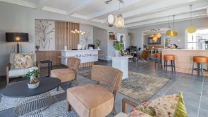 a living room with tables and chairs and a kitchen at The Salene Hotel & Cottages in Stellenbosch