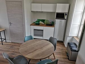 a kitchen with a table and chairs in a room at Malicorn' Appart-Hôtel in Malicorne-sur-Sarthe +9 photos