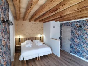 a bedroom with a white bed and a wooden ceiling at Malicorn' Appart-Hôtel in Malicorne-sur-Sarthe