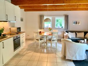 Il comprend une cuisine et un salon avec une table et des chaises. dans l'établissement Ferienwohnung 6 im Böhler Haubarg, à Sankt Peter-Ording