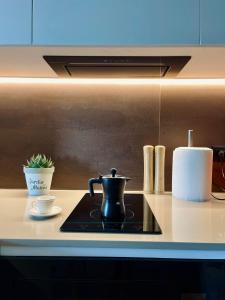 een zwarte waterkoker op een fornuis in een keuken bij Sui's Home in Tirana