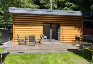 a cabin with a table and chairs on a deck at Ferienhaus Pepe in Graal-Müritz +6 photos
