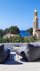 a couch and a table on a balcony with the ocean at PANORMUS Luxury House in Panormos Rethymno