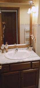 y baño con lavabo blanco y espejo. en Apartamentos Nevados 28311, en Anciles
