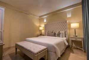 1 dormitorio con cama blanca grande y banco en Hotel Casa Canabal by Faranda Boutique, en Cartagena de Indias