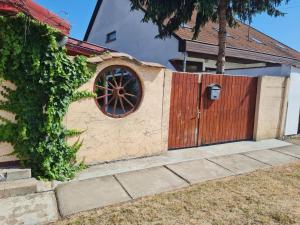 una valla con una puerta de madera con una rueda en Anna Bella Apartman en Gyula