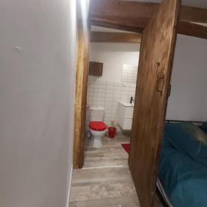 ein Bad mit einem WC und einer roten Tür in der Unterkunft In Casa in Casta