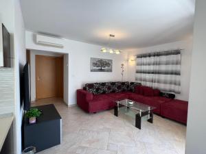 sala de estar con sofá rojo y mesa en Ana Exclusive Apartments, en Jelsa