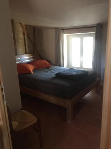 Un dormitorio con una cama con ventana. en Cosy, calme et authentique au coeur de ville, en Carcassonne