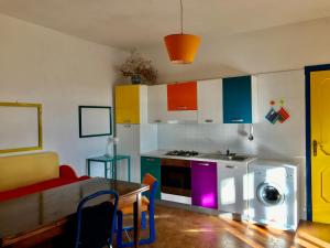 a kitchen with a table and a kitchen with colorful cabinets at Cosy apartment in a relaxing area close to Lecce in Frigole