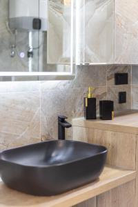 - un lavabo noir sur un comptoir dans la salle de bains dans l'établissement Piazza Square City Top Centre Apartments, à Split