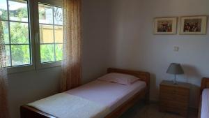 a small bedroom with a bed and a window at Palm Villa in Astris