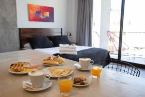 a table with breakfast foods on it with a bed at Days Inn Devoto in Buenos Aires