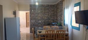 a kitchen with a table and chairs and a brick wall at Le Beau Site Chalet in El Alamein