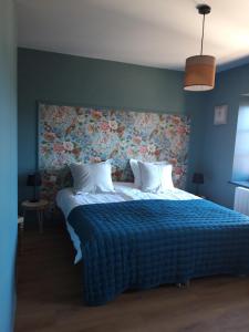 a bedroom with a large bed with a floral headboard at Domaine Gilles Copéret- Artisan-Vigneron- chambres d'hôtes Les Glycines - in Régnié