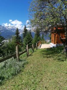 a fence on top of a hill with a house at Petit chalet Valfréjus pied des pistes in Modane