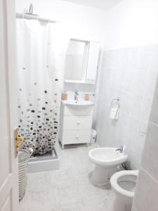 ein weißes Badezimmer mit Toilette und Waschbecken in der Unterkunft Apartament deosebit in Reşiţa