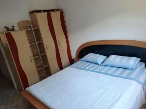 Schlafzimmer mit einem Bett mit blauen und roten Streifen in der Unterkunft Apartament deosebit in Reşiţa