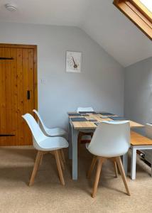 a dining room with a table and white chairs at The Stables, charming converted, 2 bedroom Cottage, Melrose in Darnick